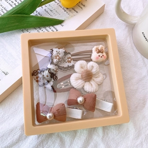 Detailed set of brown fabric bows and plush floral hair clips in a gift display box