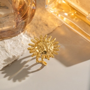 Detailed close-up of golden sun-shaped open ring with textured hammered metal finish