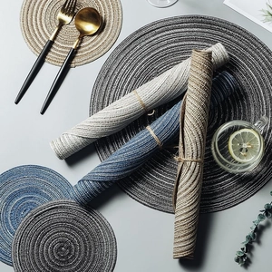 Round woven cotton table mats in gray, beige, and blue with non-slip heat insulation