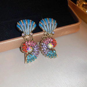 Detail of vintage gold-plated heart earrings with colorful parrot shell design in a box