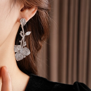 Nahaufnahme von Zirkon-Blumen-Ohrringen in Silber am Ohr des Models
