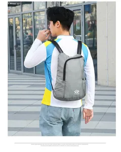 Close-up of grey lightweight folding backpack showing ripstop fabric and logo detail