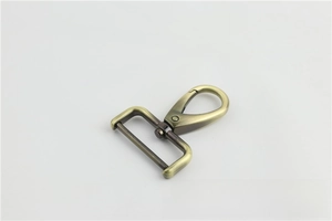 Detail of antique brass swivel snap hook with D-ring for handbag straps and luggage