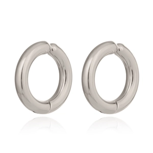 Detail of silver polished round clip-on earrings with smooth metallic finish on white surface