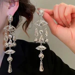 Surrealist silver tassel earrings featuring abstract eye and lip charms for women