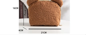 Macro detail of brown teddy plush makeup bag showing 21x16x6cm dimensions and soft texture