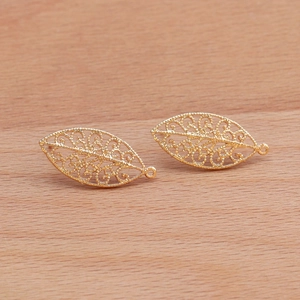 18k gold plated hollow leaf earrings with filigree design on natural wood background