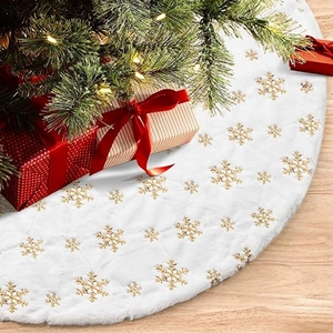 White plush Christmas tree skirt with gold sequin snowflakes on a wooden floor