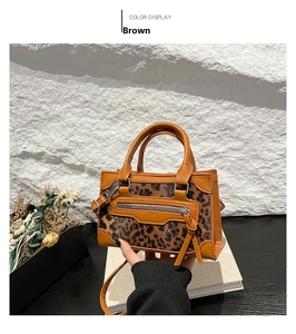 Bolso con estampado de leopardo marrón con adornos de cuero y borla en soporte blanco