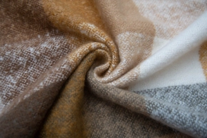 Macro shot of soft brushed plaid fabric in brown and beige colors with a focus on texture