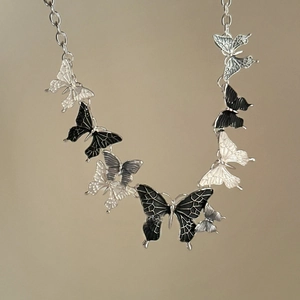 Symmetric necklace with colorful metal butterfly pendants in black, white, and silver