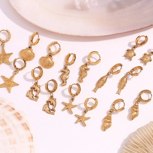 Flat lay of 18K gold plated marine charms hoops including starfish, seahorse and shells