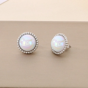 Detailed view of silver stud earrings with round white opal and beaded metal border