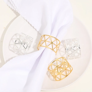 Close-up of geometric hollow triangle metal napkin rings in gold and silver finishes