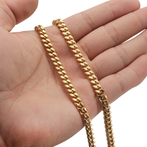 Detailed close-up of golden stainless steel Cuban chain necklace with stone set buckle