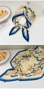 Detail of pleated floral satin scarf in cream yellow with elegant navy blue border