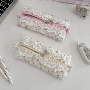 Detailed shot of quilted floral pencil cases with lace edges and sweet bow accents