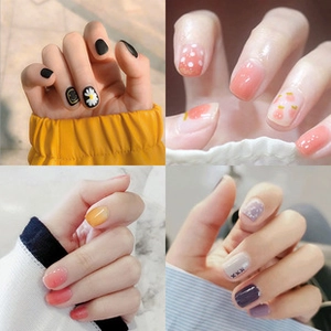 Detail view of four nail art styles including matte black daisy and peach fruit designs