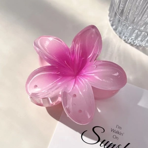 Macro shot of a pink gradient resin flower hair claw clip on a minimalist background