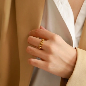 Detailed view of a gold braided Cuban link ring worn on a finger for a stylish look
