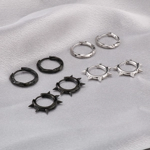 Flat lay of black and silver stainless steel earrings with Mobius and spike designs