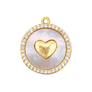 Detailed view of round gold pendant with white pearl inlay, heart detail, and zircon border
