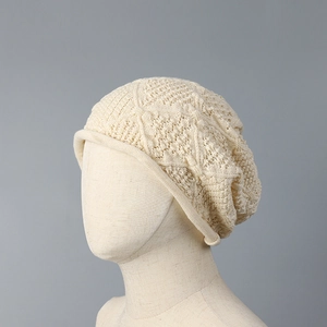 Close-up detail of a cream hollow knit beanie hat with a breathable mesh texture