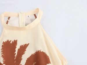 Detail of cream halter dress featuring brown palm leaf prints and a size S label