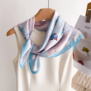 Detail of silk-feel scarf featuring blue and pink butterfly and flower patterns