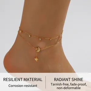Bracelet de cheville double rang doré avec lunes et étoiles porté sur la plage