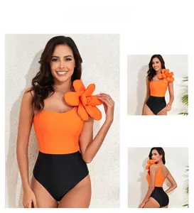 Detail of one-shoulder swimsuit with 3D floral decoration and orange-black color block