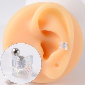 Macro detail of iridescent butterfly cartilage stud earring with stainless steel ball