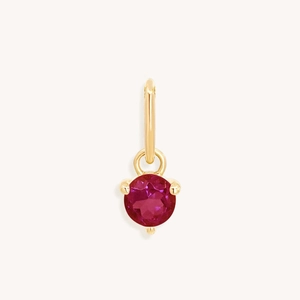 Close-up of a gold-plated round pendant featuring a brilliant ruby gemstone inlay