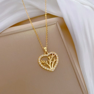 Elegant gold heart antler necklace with sparkling crystals on a jewelry display box