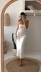 Dettaglio dell'elegante abito lungo in raso bianco avorio con design senza schiena