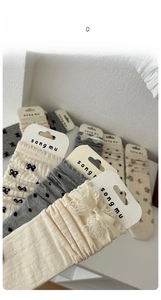 Detail of ballet style lace socks with delicate bows and breathable knit texture