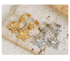 Macro shot of gold and silver double star earrings with shimmering cubic zirconia