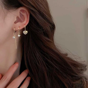 Detailed view of gold plated earrings featuring star moon and heart shaped zircon drops
