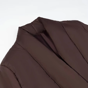 Detail of dark brown quilted puffer jacket featuring a wide V-neck collar and silky texture