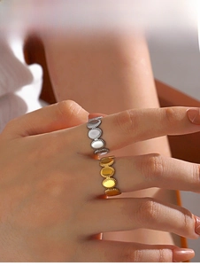 Close-up of minimalist gold and silver oval stainless steel rings worn on fingers