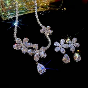 Luxury silver flower necklace and earrings set with teardrop zircon crystals on black background