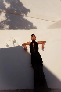 Detail of elegant black lace maxi dress with V-neckline and ruffled fishtail silhouette