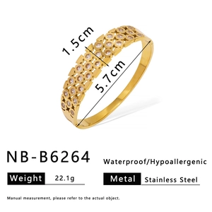 Detailed view of hollow clover pattern gold stainless steel bangle with white zircon