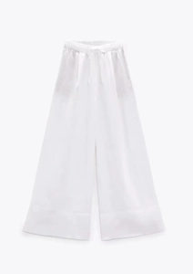 Detail einer weißen Baumwoll-Leinen-Hose mit weitem Bein und verstellbarem Kordelzug