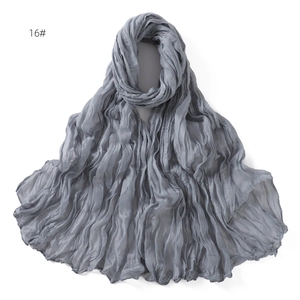 Close-up detail of grey crinkled fabric texture on lightweight breathable cotton scarf