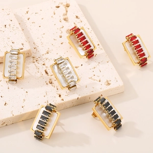 Macro shot of gold-plated rectangular earrings with white shell and inlaid cubic zirconia