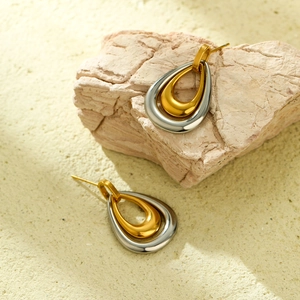 Gros plan de boucles d'oreilles gouttes bicolores avec finitions polies or et argent