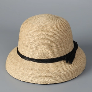 Close-up of high-quality raffia woven sun hat with elegant black mesh ribbon bow