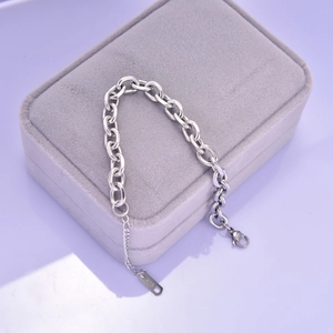 Close-up of chunky silver link bracelet with lobster clasp and K18 metal tag on velvet