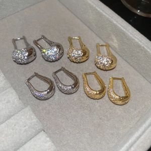 Détail de boucles d'oreilles élégantes dorées et argentées serties de zircons